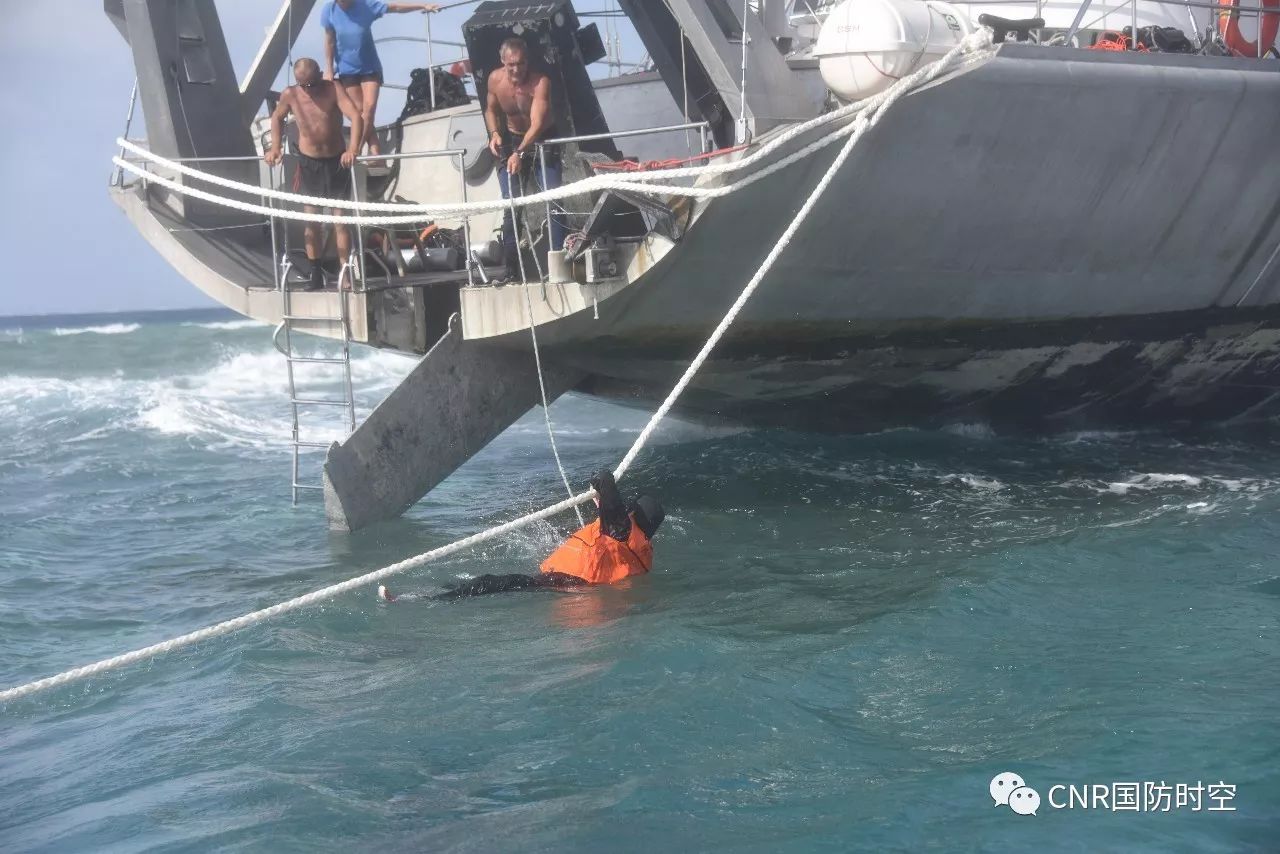 中国海警3303舰舰员跳入海中协助遇险船只拖带缆绳。
