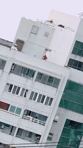 新北市消防局搜救队使用吊车将特搜人员垂吊至顶楼,从12楼持生命探测器往下搜寻,在云门翠堤大楼内有3处地方,以生命探测器发现生命讯号,立即以红线做标记。图片来源:台湾联合新闻网。