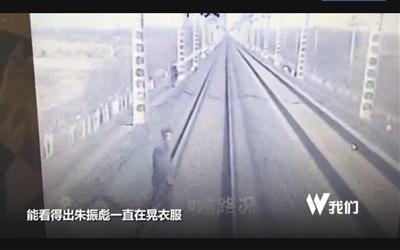 朱振彪手机视频中，张永焕翻过围栏，上了铁路。视频截图