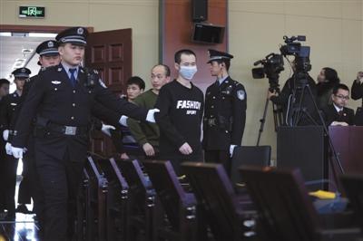 昨日,海淀法院开庭审理获取4000余万条公民信息助考诈骗案,被告人曾爱国(戴口罩者)等14名被告人被带入法庭。新京报记者王飞 摄