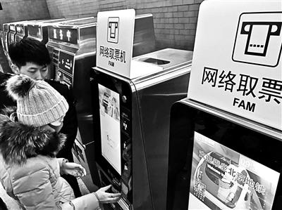 乘客在网络取票机上取地铁车票摄影/本报记者 黄亮