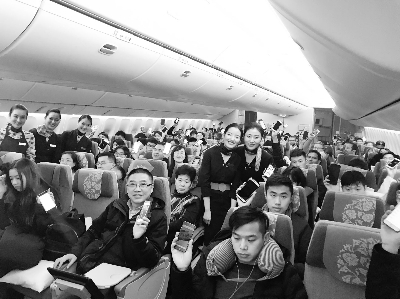 "空中开机"的乘客们举着手机与空乘人员合影 东航供图法制晚报讯(记者