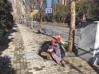 1月10日，上海浦东，午饭时间，一位工人躺在路边休息。新京报记者 罗芊 摄