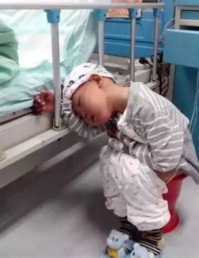 治疗时,因为难受杜思瀚坐在痰盂上睡着了。图片来源:成都商报