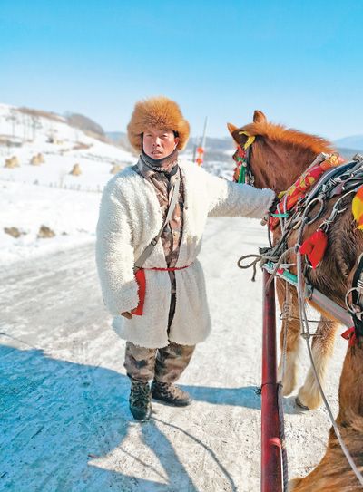车夫张爱国热情招呼游客体验马拉雪橇。 本报记者 周人杰摄