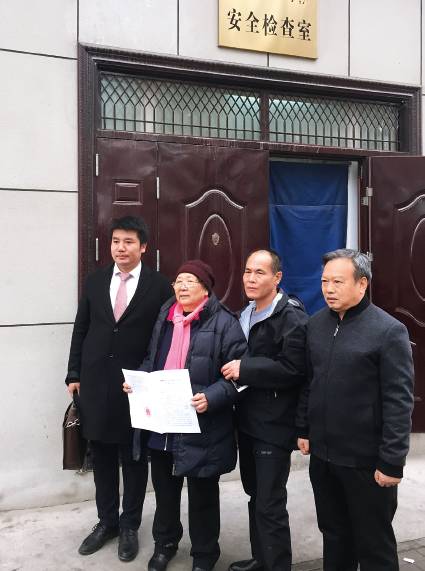 2017年11月30日,周远拿到无罪判决书后走出法院。右起:伊宁三中老校长龙富初、周远、周母李璧贞、代理律师刘征。摄影/杨宝璐