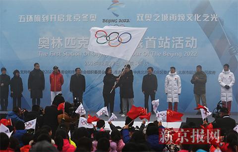 北京冬奥组委秘书长韩子荣将奥林匹克会旗交至青少年手中。
