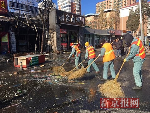 环卫工正在清理爆燃时散落的玻璃碎片。 新京报记者 王飞 摄