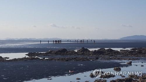 12月5日上午,在仁川市灵兴岛一海水浴场南侧滩涂,海警发现事故钓鱼船船长吴某遗体。(图片来源:韩联社)