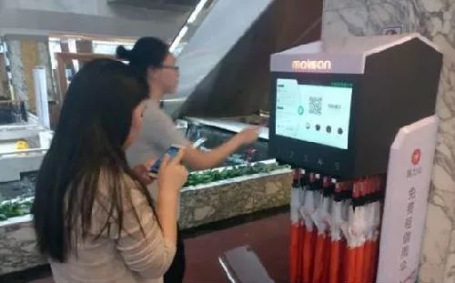 ▲民众在一个地铁站附近租用共享雨伞。(香港《南华早报》网站)