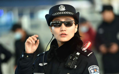 资料图片:一名郑州铁路警员2月5日在火车站内戴着人像比对警务眼镜执勤。(法新社)