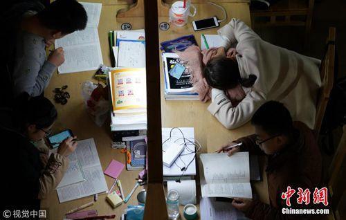  12月7日，郑州大学新校区，考研进入倒计时，记者探访高校“考研族”。图为夜晚的图书馆里，考研学生占了相当大比例。马健 摄 图片来源：视觉中国