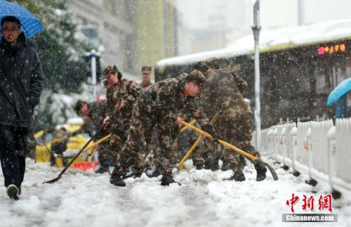 1月4日,江苏驻地边防总队机关勤务保障大队组织80多名官兵走上街头,铲除积雪,确保群众顺利出行。 中新社发 章善玉 摄 图片来源:CNSPHOTO