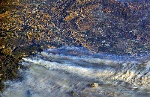 图为美国宇航员布瑞斯尼克12月6日在国际空间站上拍摄的照片，显示南加州林火的滚滚浓烟清晰可见。（图片来源：路透社）