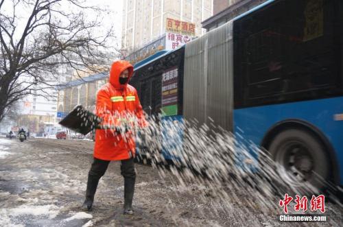 1月4日凌晨3点郑州市的环卫工人们就到岗除雪。图为环卫工人在街头撒融雪剂。 韩章云 摄 1月4日凌晨3点郑州市的环卫工人们就到岗除雪。图为环卫工人在街头撒融雪剂。 韩章云 摄