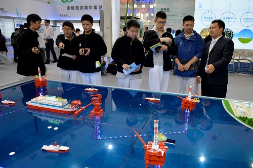 资料图片：2014年4月17日，几名北京三十五中的同学在展览会上参观由中国核工业集团公司研发的浮动式核电站模型。新华社记者 李鑫 摄