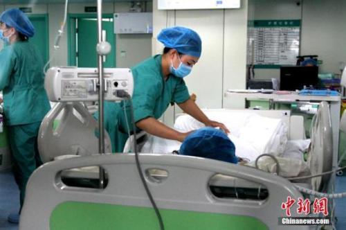 资料图:医护人员在给患者治疗。 中新社记者 田进 摄