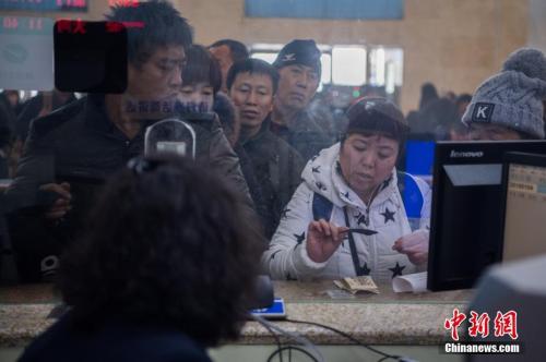 资料图:1月4日,山西太原火车站,旅客在人工售票窗口买到出行的火车票。 中新社记者 韦亮 摄