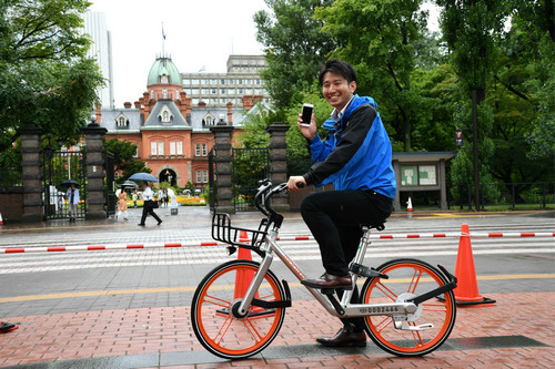 资料图片:8月22日,在日本北海道札幌市,一名当地电视台记者试骑摩拜单车。新华社记者 华义 摄