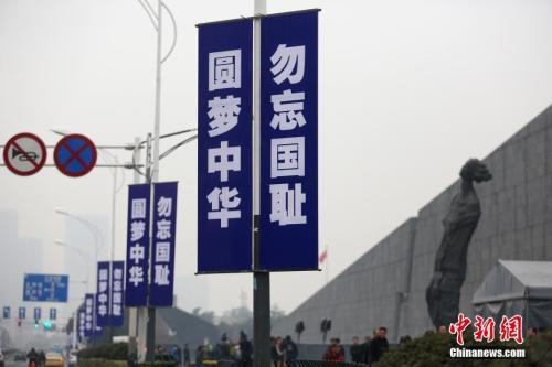 12月7日，侵华日军南京大屠杀遇难同胞纪念馆周边的主干道路灯杆悬挂“圆梦中华 勿忘国耻”的标语。中新社记者 泱波 摄