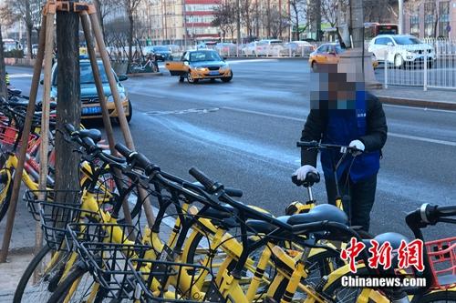 某街道办事处工作人员看到倒地的共享单车主动扶起来摆好。中新网 吴涛 摄