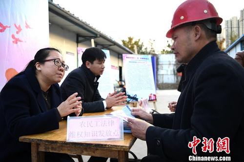 资料图:法律工作者为外来务工人员提供法律咨询。中新社记者 韩苏原 摄