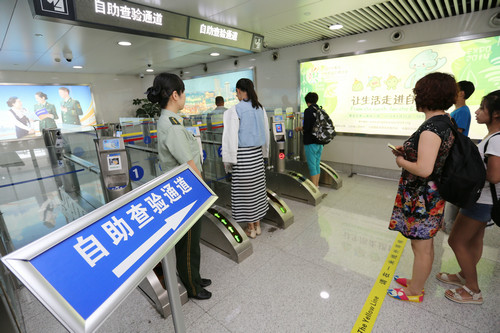 资料图片：2014年7月29日，中国旅客在青岛机场边检站自助通关。新华社发