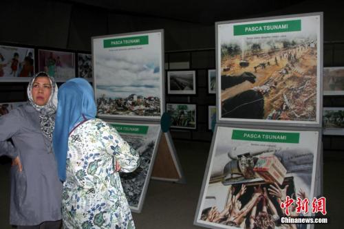 资料图：2014年12月25日，观众在印尼亚齐市中心的海啸博物馆内参观海啸遗骸、图片展，纪念海啸灾难10周年。 中新社发 顾时宏 摄