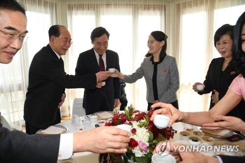  2月11日，在华克山庄酒店，韩国总理李洛渊（中）与金与正（右二）等朝鲜冬奥高官团共进午餐。图为列席人士在席间举杯。（图片来源：韩联社）