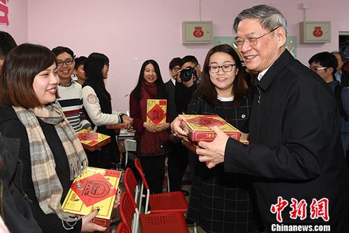 1月20日,国台办主任张志军来到北京中国人民大学,走访该校台湾学生宿舍,并与在校台生开展座谈等互动活动。图为张志军向参与座谈会的台湾师生代表赠送节日礼物。 中新社记者 崔楠 摄