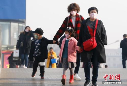 2016年12月19日，北京被雾霾笼罩，民众戴防雾霾口罩出行。 中新社记者 杜洋 摄