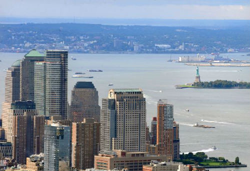 资料图：美国纽约曼哈顿下城金融区一带的高楼与自由女神像隔河呼应。（新华社）