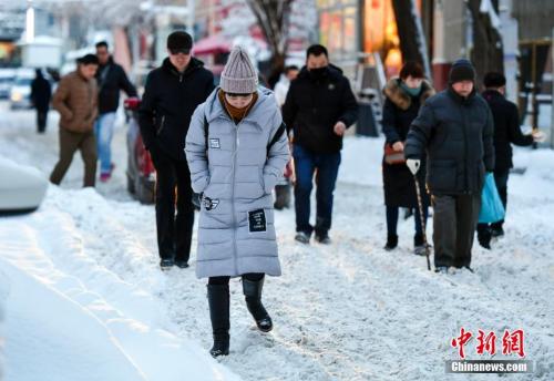 资料图：2017年12月28日，新疆乌鲁木齐降雪后，民众在雪中小心翼翼行走。中新社记者 刘新 摄