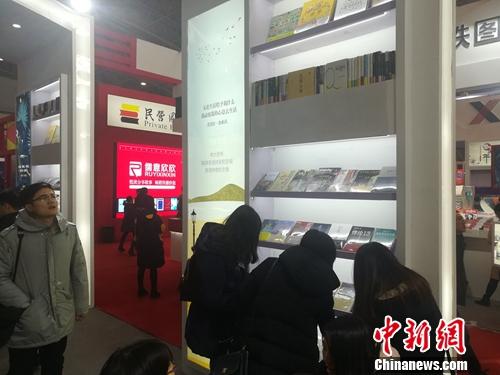 2018北京图书订货会上,读者在某个展台前驻足翻看纸书。上官云 摄