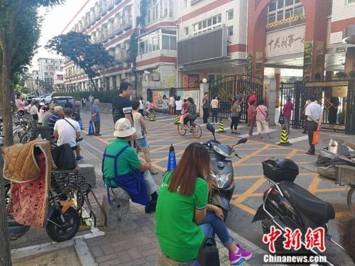 资料图:中关村一小门外等候接孩子的家长 中新网记者 张尼 摄