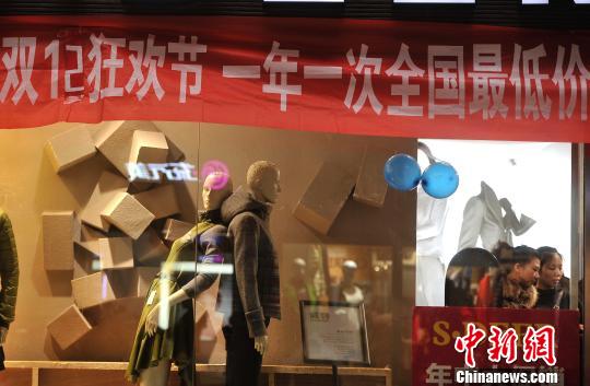 图为一服装店挂着“双12”活动横幅。 陈超 摄
