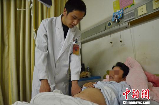 图为腹部隆起的汤女士在手术前接受检查。 吴刘佳 摄