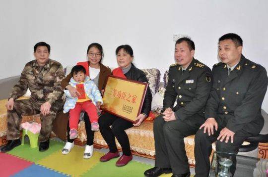 ▲金溪籍军官支晶的母亲、妻子和女儿,喜捧“三等功臣之家”牌匾。