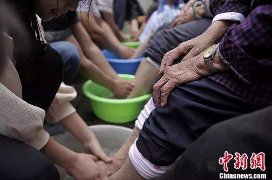 ↑志愿者为老人们洗脚。 陈超 摄