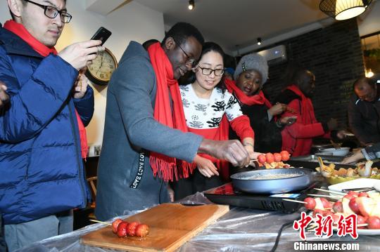“祈福冬奥、乡宴柳沟”系列活动7日、8日在北京延庆井庄镇柳沟村举行。图为外国友人体验中国年。 阿吉 摄