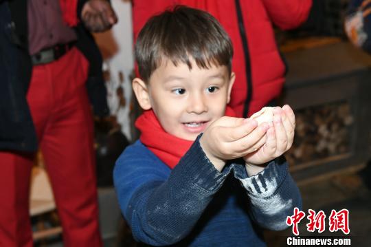 “祈福冬奥、乡宴柳沟”系列活动7日、8日在北京延庆井庄镇柳沟村举行。图为外国友人体验中国年。 阿吉 摄