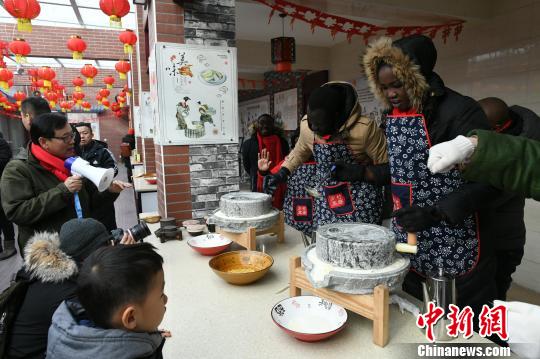 “祈福冬奥、乡宴柳沟”系列活动7日、8日在北京延庆井庄镇柳沟村举行。图为外国友人体验中国年。 阿吉 摄