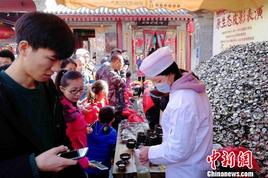 图为民众排队品尝摔碗酒。 燕武 摄 西安春节假期接待游客逾1269万人次 民俗游受热捧