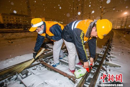 铁路职工在进行道岔除雪作业,防止因冰雪堆积导致道岔作用不良 王曙天 摄