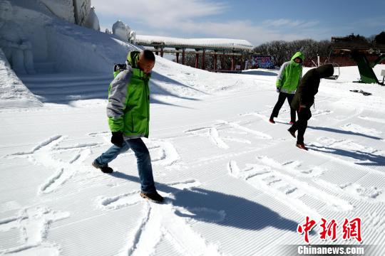 雪地上踩出“妈妈对不起，这个春节不能陪你”的大字　王中举　摄