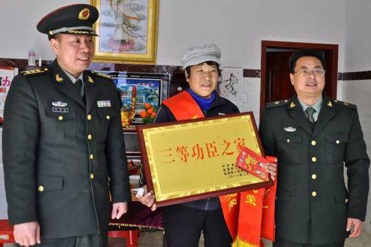 ▲金溪籍军人杨凯的母亲,喜捧“三等功臣之家”牌匾。