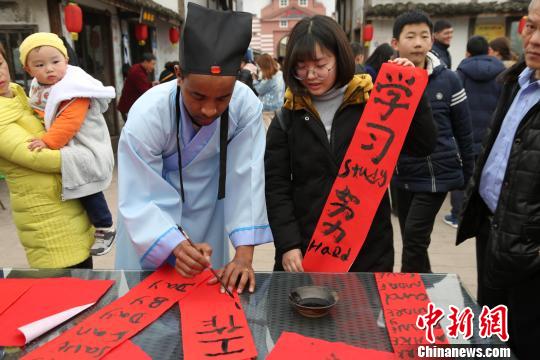 图为外籍友人为民众送新春祝福。　杨孝勇　摄