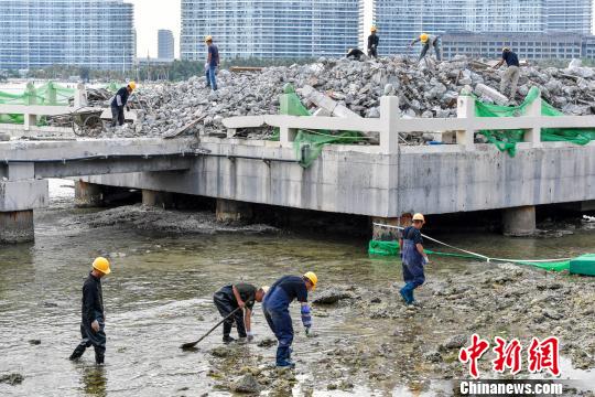 资料图:三亚洲际度假酒店海上餐厅项目拆除,工人正在海水中捡拾落入的建筑垃圾,避免二次污染。 骆云飞 摄