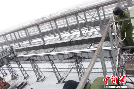 图为电工师傅检修照明灯。(孙晓梦摄)