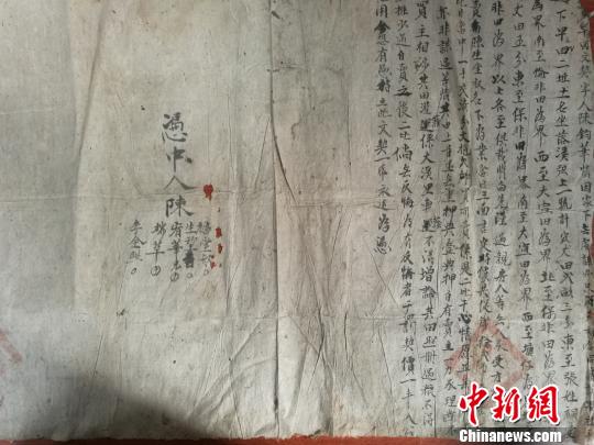 近日,江西新干县档案馆工作人员在清理民国档案时,发现一份盖有官印的土地买卖文契。 郑剑平 摄 近日,江西新干县档案馆工作人员在清理民国档案时,发现一份盖有官印的土地买卖文契。 郑剑平 摄